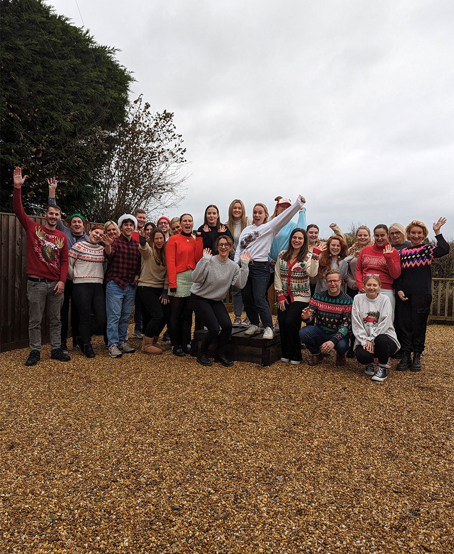 A group of people stood outside in festive Christmas jumpers.
