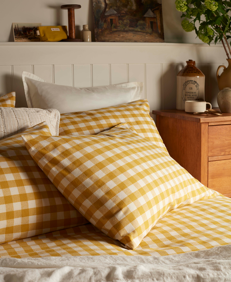Close up on bed with bright yellow gingham check pattern.