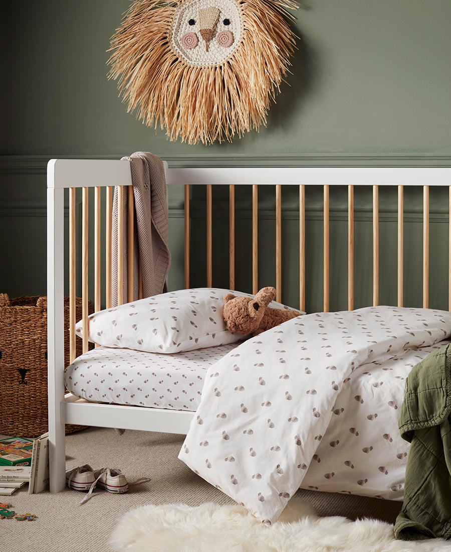 Two sisters are in a cosy pink bed whispering to each other
