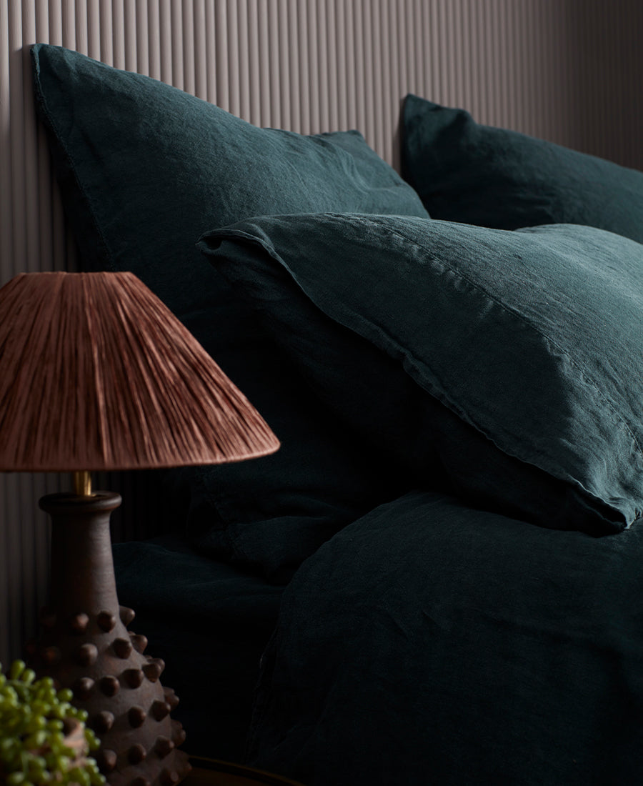Natural linen bedding is layered with throws and cushions