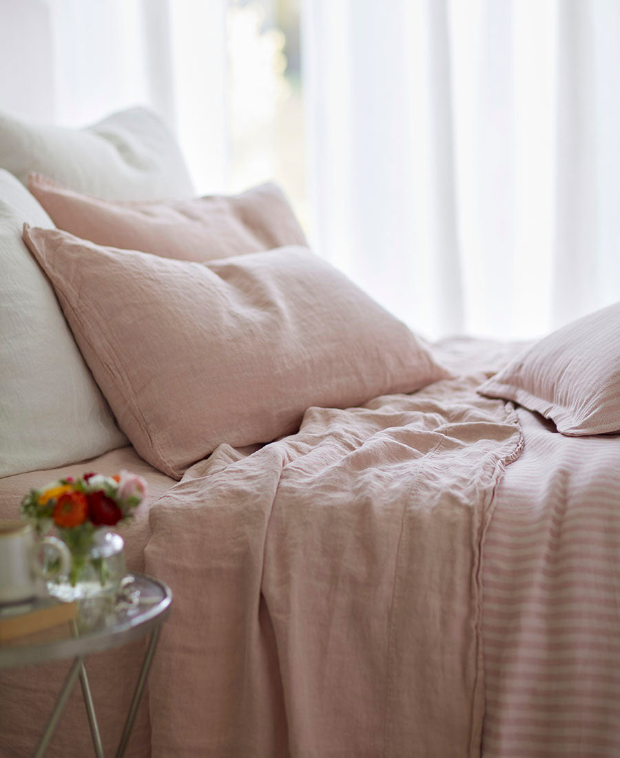 A red bed with cosy throws and cushions.