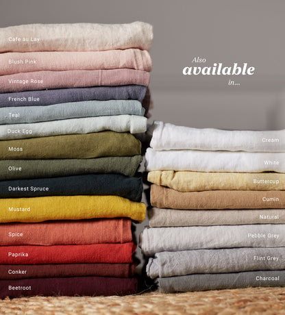 Two neat piles of linen fabrics in lots of different complementary colours.